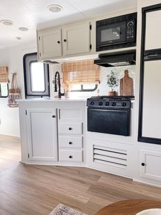 a kitchen with white cabinets and black stove top oven in the center of the room