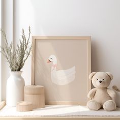 a teddy bear sitting next to a framed duck