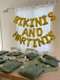 the table is set up with many bags and gold balloons that spell out'b k n y s, m & d