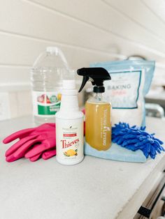 cleaning supplies sitting on top of a counter next to a bottle of cleaner and gloves