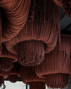 a room filled with lots of brown cords hanging from the ceiling