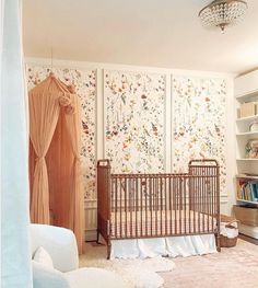 a baby's room with a crib, chair and bookshelf in it