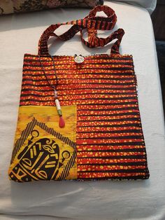 These women's shoulder bags are reversible and washable allowing for different color combinations and variations. Each handbag has a pocket on each side capable of more organization. Made from 100% cotton, these glorious African-print bags are completely unique, all including a decorative beaded fob for added pizzazz. These prints brighten up any outfit. Each is an original and signed by me, the designer. I was inspired by a wonderful aide I had while in a physical rehab facility who gifted me with some African fabric and I was hooked - thus the name 'Sister Comfort'. I hope you enjoy these bags as much as I have enjoyed creating them for you! Yellow Cotton Bags With Pockets, Orange Cotton Bag For Everyday Use, Red Cotton Pouch Bag, Orange Cotton Bags For Everyday Use, Orange Cotton Travel Bag, Eco-friendly Yellow Cotton Shoulder Bag, Rectangular Cotton Hobo Bag With Pockets, Orange Cotton Everyday Bag, Square Cotton Bags With Pockets