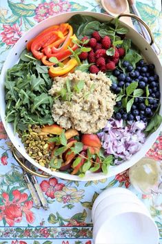 a bowl filled with berries, blueberries and other vegetables on top of a table