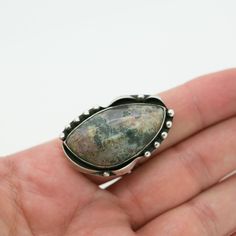 "This beautiful piece is handcrafted with exquisite detailing and features a genuine mottled blue-grey Agate stone that measures 1.5\" long and almost 1\" at its widest point. This measurement includes the solid sterling setting with its studded and gently curved ribbon-like design. The band fits a US size 10 finger and cannot be re-sized as the stone is already set (though you may order a custom ring). This ring is one of a kind and has matching earrings to go with it. The earrings measure 1.25 Bohemian Silver Jasper Jewelry, Artisan Jasper Teardrop Jewelry, Unique One-of-a-kind Ocean Jasper Jewelry, Unique Jasper Ring Jewelry, Artisan Silver Jasper Jewelry, Teardrop Agate Jewelry With Large Stone, Unique Silver Moss Agate Jewelry, Teardrop Jasper Jewelry With Natural Stones, Adjustable Moss Agate Gemstone Jewelry