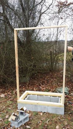 a man standing next to a wooden frame