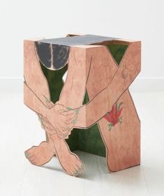 a wooden sculpture with two hands holding each other's arms and one hand on the ground