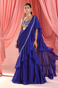 Electric blue pre-draped ruffle saree in georgette and organza base. Paired with a floral embroidered blouse.
Components: 2
Pattern: Embroidered
Type Of Work: Sequins, Pearls, Glass beads, Zari, Flower Applique
Neckline: Sweetheart
Sleeve Type: Sleeveless
Fabric: Saree: Organza and Georgette, Blouse: Georgette, Lining: Satin
Color: Blue
Occasion: Sangeet - Aza Fashions Saree Organza, Sequins Saree, Ruffle Sarees, Simple Saree Designs, Fancy Sarees Party Wear, Ruffle Saree, Saree Gown, Simple Sarees, Blouse Hand Designs