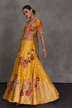 Look your best on wedding occasions like haldi and mehendi in this beautiful yellow Banarasi floral lehenga. It comes with a green net dupatta. Suit Sharara, Floral Lehenga, Sharara Suits, Designer Lehengas, Lehenga Online, Fashion Journals, Traditional Fabric, Anarkali Suit, Net Dupatta