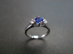 This brilliant three-stone engagement ring is set in 14K White / yellow gold. The center stone, a 5mm round brilliant cut natural blue sapphire is set in a four prong setting and adorned by two round brilliant cut diamonds with total carat weight of 0.20cttw. Diamonds Quality: D-F in Color and VS in Clarity with Heart and Arrow (Ideal cut) Currently made to order pieces may take up to 10-15 business days to complete, or let me know if you need it urgent. You may also like: A similar diamond and Timeless Blue Wedding Dress, Elegant Three Stone Sapphire Ring For Wedding, Elegant Three-stone Sapphire Ring For Wedding, Luxury Three Stone Sapphire Wedding Ring, Luxury Three-stone Sapphire Wedding Ring, Sapphire Three Stone Wedding Diamond Ring, Platinum Three Stone Sapphire Ring Gift, White Gold Three Stone Sapphire Wedding Ring, Three Stone Sapphire Ring For Wedding