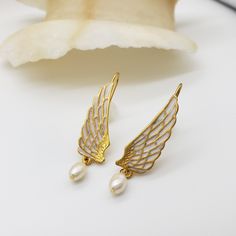 These ornate Swan Wing Earrings will add an elegant touch to any outfit. With delicate detail, they have the power to make a statement and turn heads. Perfect for any occasion. Materials: pewter with gold finish, epoxy, freshwater pearl drop Length: 1 3/4" Gift box included From the collections of the Rijksmuseum, Amsterdam Swan Wings, Wing Earrings, Delicate Details, Late 20th Century, Pearl Drop, Gold Finish, Freshwater Pearls, Simple Designs, Amsterdam