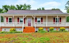 a house with red shutters on the front porch