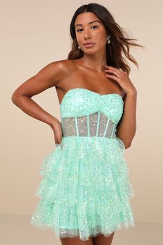 The Lulus Illustrious Glow Mint Green Sheer Tulle Sequin Tiered Mini Dress is perfect for any occasion that calls for extra extravagance! This sensational dress features a sparkling sequin design across the tulle-mesh construction that shapes a strapless, bustier-inspired bodice with sheer mesh paneling (along with supportive boning), a gathered bust with padded cups, and a sweetheart neckline with hidden no-slip strips. The high, fitted waist sits atop a fun and frilly tiered skirt that finishe Rapunzel Wedding Theme, Rapunzel Wedding, Sheer Clothing, Tulle Homecoming Dress, Tier Dress, Strapless Bustier, Tiered Mini Dress, Tiered Ruffle Dress, Sequin Design