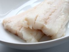 two pieces of fish on a white plate