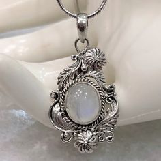 Simply Beautiful And Perfect For Any Color Outfit! Gorgeous Crafted And Detailed Filigree (Scrolls, Florals, Tendrils) Sterling Silver Pendant Featuring A Large Jelly Bean-Like Rainbow Moonstone. Stone Has A Pale Blue Sheen And Near Transparent Look. Pendant Measures 1.5” Long Marked 925 Comes With 20” Italian Sterling Silver Snake Chain Intricate Design Moonstone Jewelry, Exquisite Engraved White Jewelry, Exquisite White Engraved Jewelry, Exquisite Silver Oval Pendant Jewelry, White Oval Necklace With Intricate Design, Elegant Engraved Moonstone Jewelry, Intricate Moonstone Jewelry For Gift, Intricate Moonstone Jewelry As A Gift, Silver Engraved Moonstone Necklace