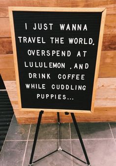 a sign that says i just wanna to travel the world, overspend at lullilemon, and drink coffee while cuddling puppies