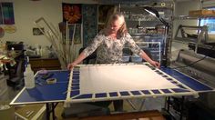 a woman standing in front of a table with blue and white tiles on it,