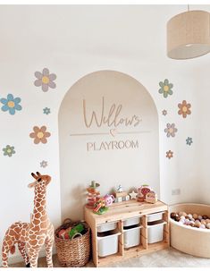 a child's playroom with giraffes and flowers on the wall