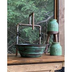 a green sink sitting on top of a window sill next to a wooden cabinet