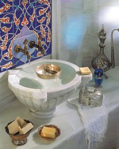 a white sink sitting on top of a counter next to a blue tile covered wall