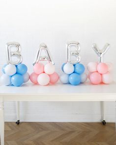 balloons spelling out the word baby on a table