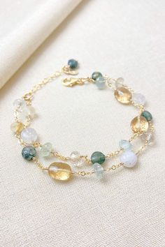 This artisan-crafted, multi-gemstone style bracelet boasts striking green gems, including aquamarine and moss agate, paired perfectly with lustrous golden quartz gems.  Rainbow moonstone adds an ethereal glow.

This is a timeless accessory perfect for weddings and other special occasions, as well as elevating your everyday style.

Handcrafted in southeastern Georgia. Gold Bracelets With Natural Stones And Mineral Crystal, Gold Jade Crystal Bracelet With Natural Stones, Elegant Bracelets With Natural Stones And Mineral Crystal, Adjustable Green Mineral Crystal Jewelry, Green Multi-stone Bracelets For Gifts, Gold Bohemian Crystal Bracelet With Gemstones, Unique Green Gemstone Bracelets, Green Citrine Jewelry With Gemstone Accents, Green Citrine Jewelry With Natural Stones