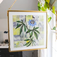 a painting hanging from a gold frame on a wall next to a potted plant