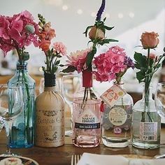 flowers in vases and bottles on a table