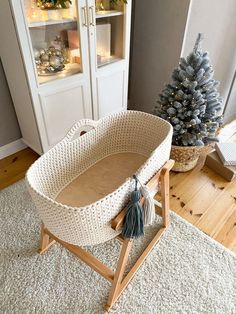 a white wicker baby crib next to a christmas tree