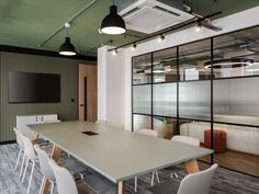 a conference room with tables and chairs in front of a flat screen tv on the wall