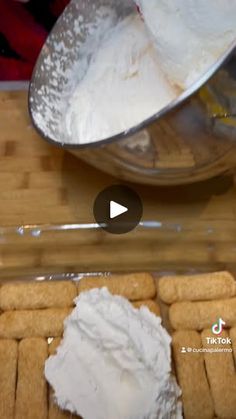 a wooden table topped with lots of food next to a metal bowl filled with whipped cream