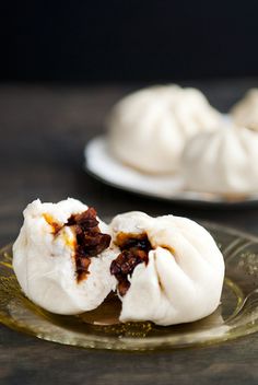 two plates filled with dumplings on top of a wooden table