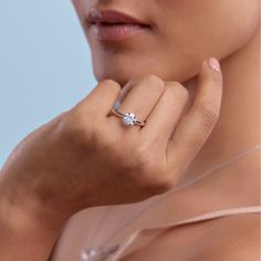 a close up of a person wearing a ring with a diamond on the middle finger