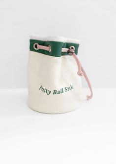 a small white bag with green trim on the bottom and pink string at the bottom