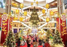 people are walking through an indoor mall decorated for christmas