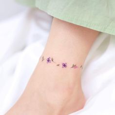 a woman's foot with small flowers on it