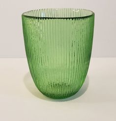 a green glass vase sitting on top of a table