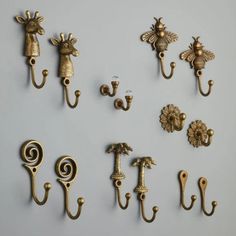 there are many different types of hooks on the wall together, including one with a bee