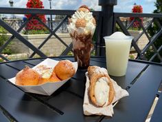 two pastries on a table next to a drink and ice cream in a container