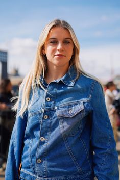 a woman with blonde hair wearing a denim jacket