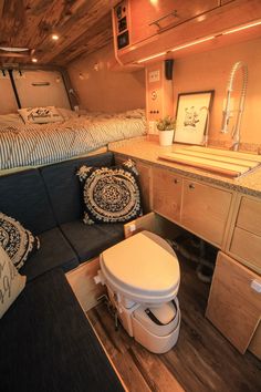 the interior of a small rv with a bed, sink and couch in front of it