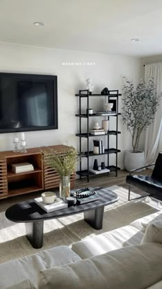 a living room filled with furniture and a flat screen tv mounted to the side of a wall