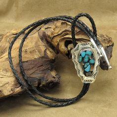 This is a unique vintage sterling silver turquoise and abalone shell collage bolo tie. This is truly a one-of-a-kind work of art. The silver bolo measures 2 7/16" tall by 1 9/16" wide. The inlay collage design measures 1 9/16" tall by 7/8" wide. The bolo cord measures 37" in length. There is no artist's hallmark on the piece but the back of the bolo is stamped (STERLING). The sterling silver bolo comes on a black leather cord that is a timeless design. Please message me with any questions you ma Luxury Southwestern Sterling Silver Bolo Tie, Luxury Sterling Silver Bolo Tie For Gift, One Of A Kind Adjustable Western Jewelry, Handmade Southwestern Turquoise Bolo Ties, Artisan Turquoise Bolo Ties With Concho, Handmade Turquoise Vintage Bolo Ties, Handmade Artisan Turquoise Bolo Ties, Artisan Handmade Turquoise Bolo Ties, Artisan Turquoise Bolo Ties For Gifts