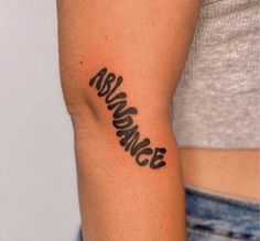 a woman's arm with the word awesome tattooed on her left arm, in black ink