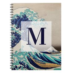 the letter m is in front of an ocean wave spiral notebook with blue and white waves