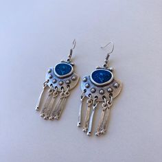 Silver Boho Dangle Earrings with Blue Enamel and Fringe Elevate your style with our Ethnic Silver Dangle Drop Earrings with Blue Enamel, handmade from silver-plated Zamac. Perfect for everyday Boho flair and a thoughtful gift for your girlfriend. Discover comfort in Bohemian design. The unique dangle drop style adds a touch of individuality, making them a versatile choice for any occasion. The silver-plated Zamac not only ensures durability but also brings a subtle gleam to enhance your overall look. Zamac, composed of zinc, aluminum, magnesium, and copper, ensures both strength and a lightweight feel. The silver plating adds a touch of refinement, creating a captivating interplay of light and shadow. We prioritize comfort in our design, allowing you to enjoy these earrings effortlessly th Blue Bohemian Metal Earrings, Bohemian Blue Metal Earrings, Blue Metal Earrings With Latkans, Blue Bohemian Earrings With Latkans, Bohemian Blue Earrings With Latkans, Bohemian Blue Danglers, Blue Metal Earrings For Festivals, Bohemian Blue Metal Chandelier Earrings, Blue Metal Bohemian Chandelier Earrings