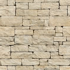 a stone wall that has been made out of several different types of stones and is beige