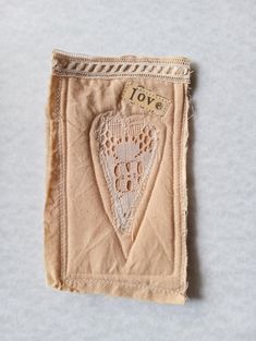 a piece of cloth with an embroidered heart on the front and back of it, sitting on top of a white surface