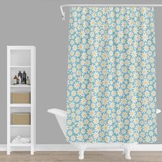 a shower curtain with blue and yellow daisies on it in front of a gray wall