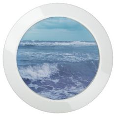 an image of the ocean with waves coming in from the water through a round window